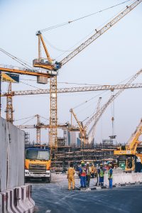 An image of a construction site with numerous high yellow cranes.